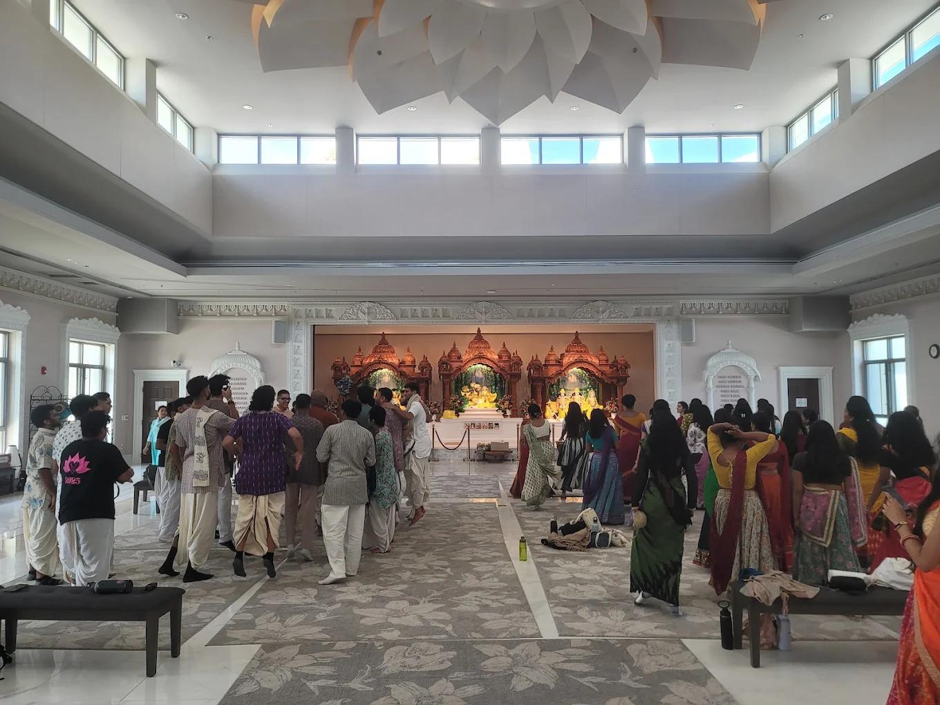 Inside the ISKCON temple near Washington, D.C. — devotees before the carved altar beneath the lotus ceiling.