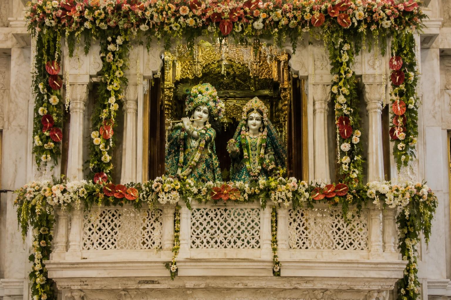 The deities framed in a jharoka decorated with floral garlands.